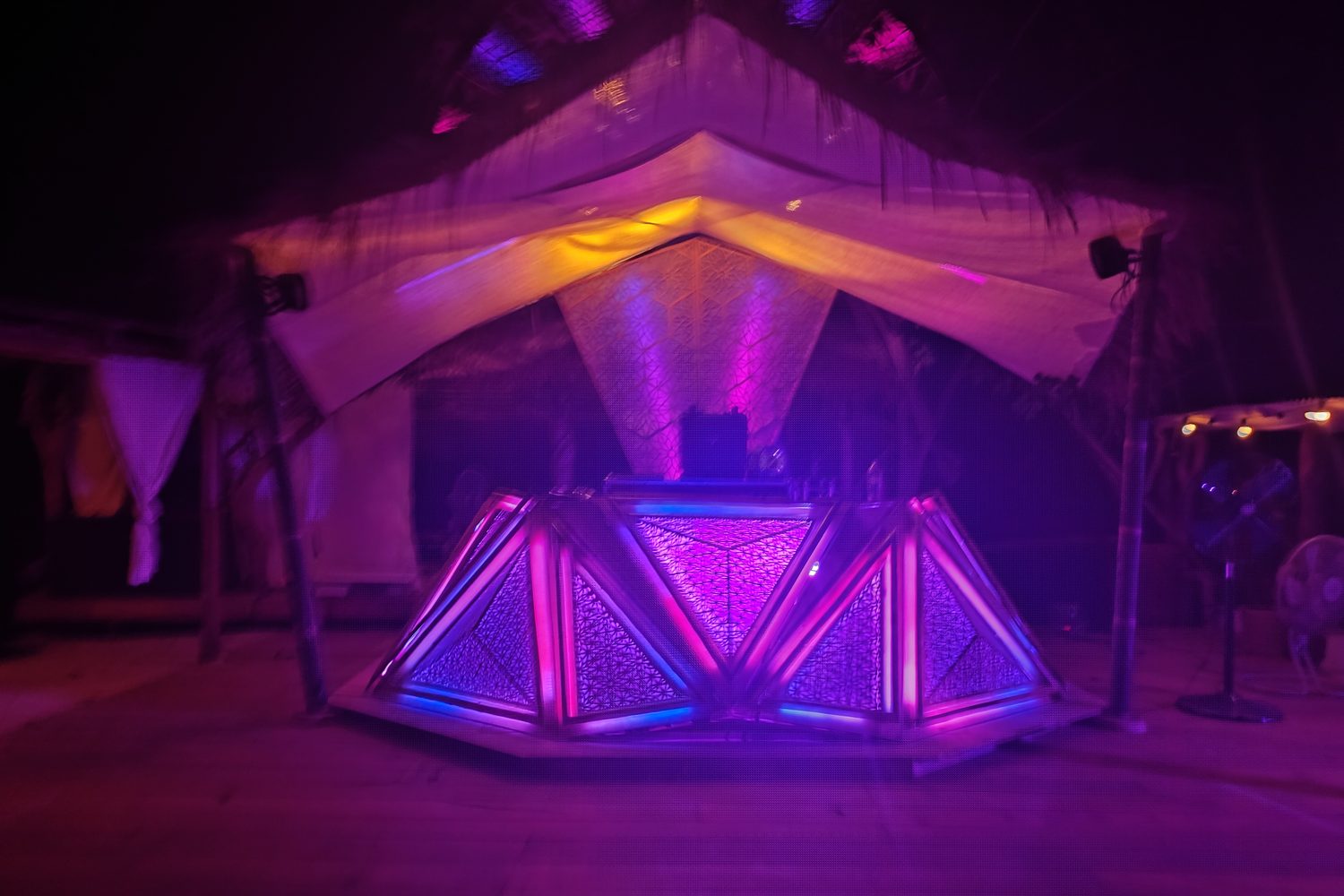 The Portals Booth lit in magenta and violet under its canopy